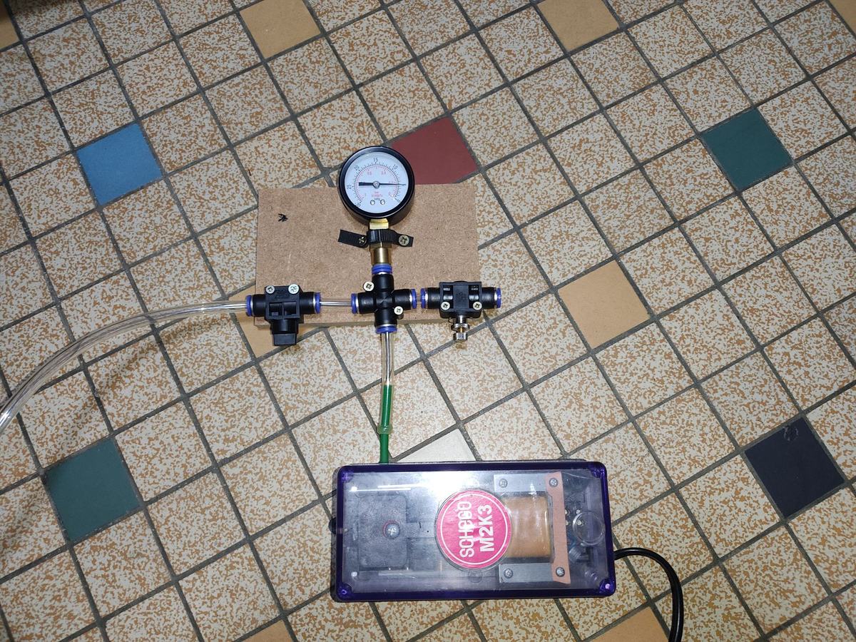 Pompe Schego branchée au circuit : raccord en T et vacuomètre sur une plaque